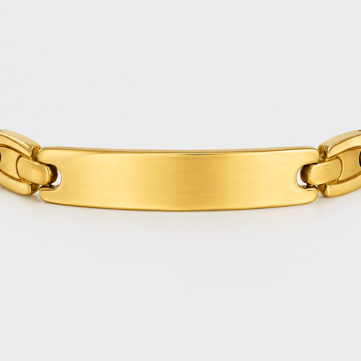 Gold chain bracelet on a light gray background