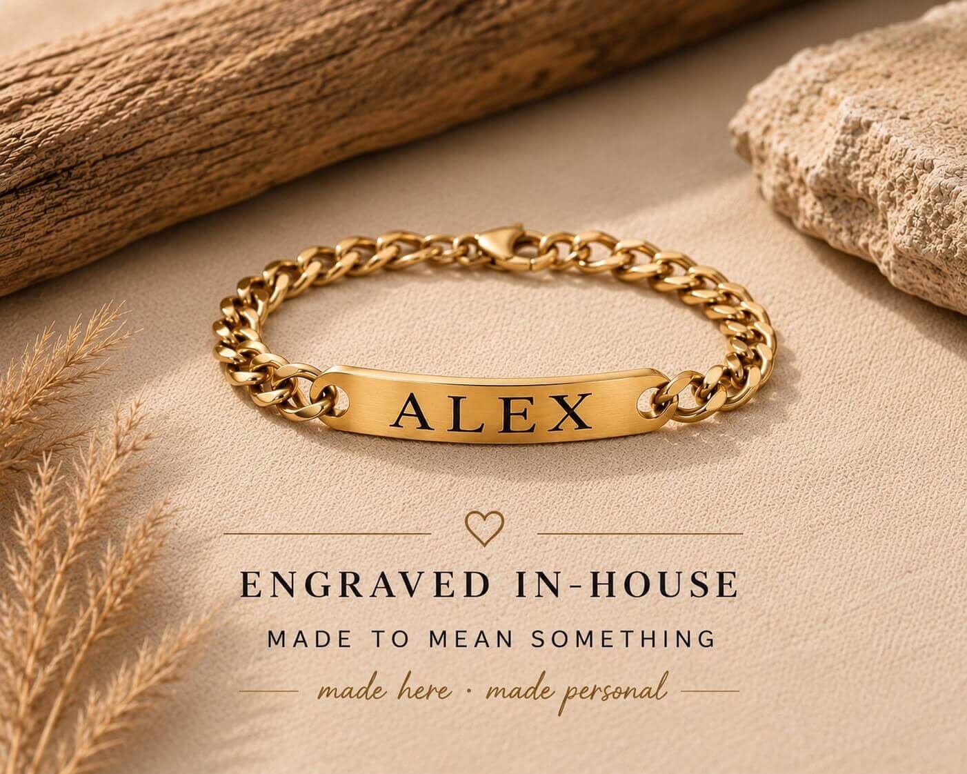 Gold bracelet with 'ALEX' engraving on a beige surface with natural elements.