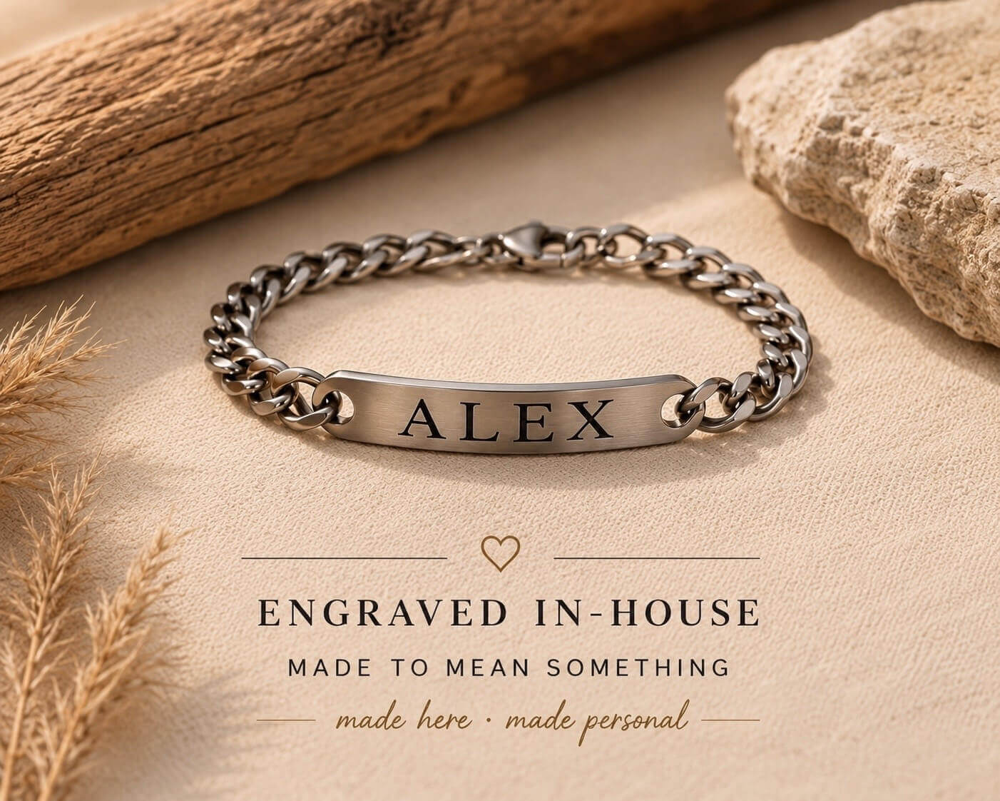 Silver bracelet with engraved name 'ALEX' on a beige surface with natural elements.